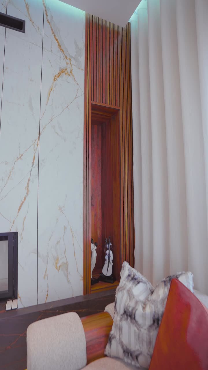 Intérieur d'une villa aménagée : mur en marbre veiné, chambre habillée et éclairage travaillé.